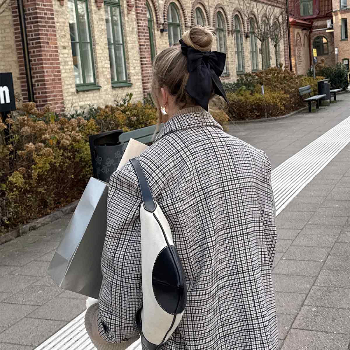 Sløyfescrunchie i 100 % mulbærsilke – elegant hårstrikk med blank sort overflate